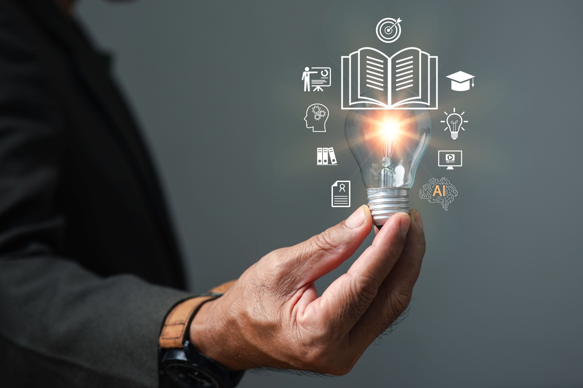 Businessman holding glowing light bulb with education and innovation icons, symbolizing learning, knowledge, creativity, AI technology, and smart ideas for future success in digital education